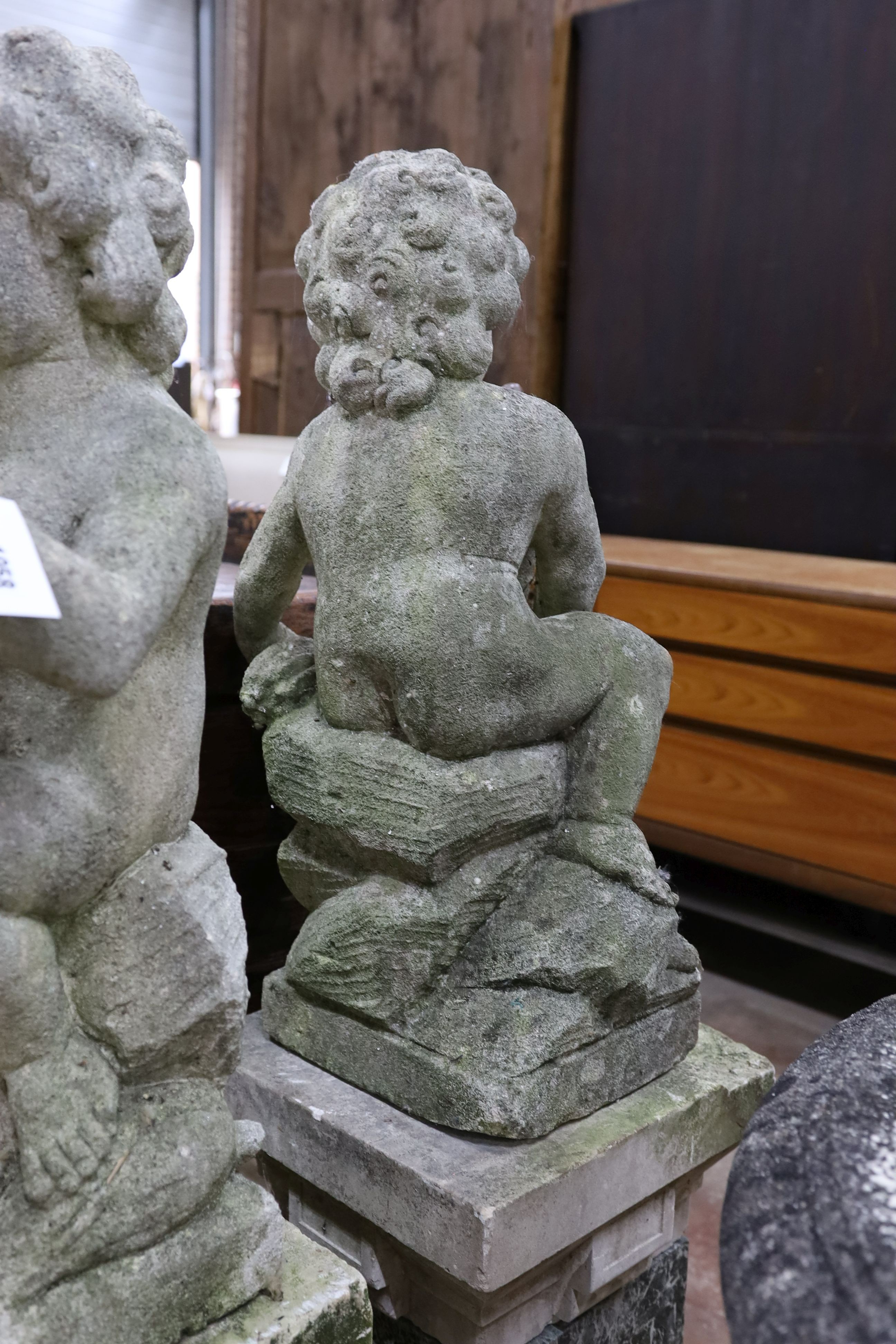 A pair of reconstituted stone cherub and dove garden ornaments on faux marble plinths, height 116cm